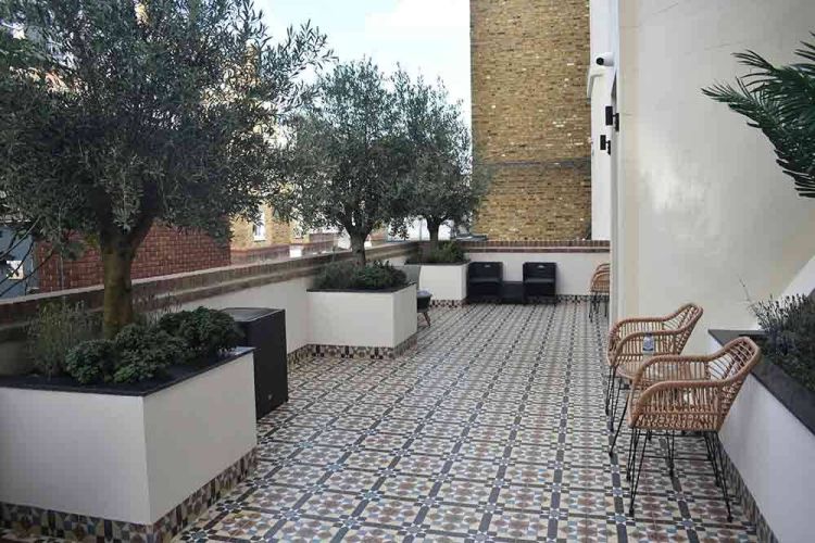 ταράτσα με πλακάκια και διακόσμηση με γλάστρες και δέντρα