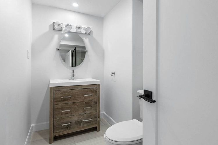 μικρό WC με λευκά πλακάκια και πρακτική διάταξη χώρου